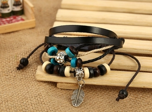 Close-up of vintage multi-layer beaded leather bracelet with a silver feather pendant
