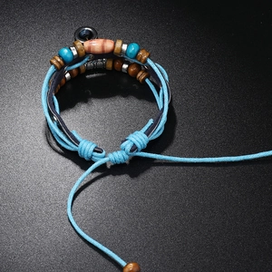 Detailed close-up of multilayer bohemian beaded bracelet with adjustable cord and wooden beads