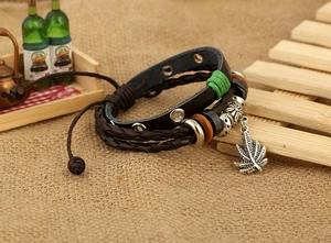 Détail macro d'un bracelet multicouche en cuir avec pendentif érable et perles bois