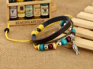 Détail d'un bracelet multicouche en cuir bohème avec perles en bois et pendentif poisson