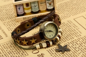 Gros plan sur la montre en cuir vintage avec clous étoilés et pendentif étoile de mer