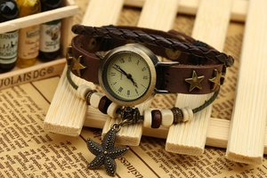 Détail macro d'une montre vintage en cuir avec clous étoiles et pendentif étoile