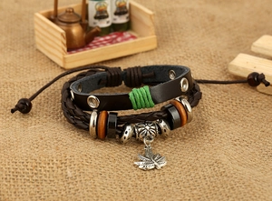 Détail d'un bracelet en cuir multicouche avec un pendentif feuille d'érable vintage