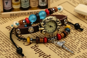 Détail de la montre rétro en cuir avec cadran en bronze, perles colorées et pendentif métal