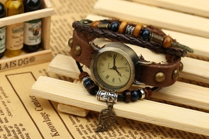 Detail of vintage multilayer leather strap watch with bronze dial and wooden beads