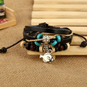 Handmade multilayer leather bracelet with wooden beads and silver fish charm on rustic burlap