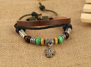 Macro detail of multi-layer leather bracelet with owl charm and colorful wooden beads