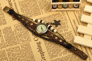 Détail de montre bracelet vintage en cuir marron avec rivets étoile et breloque étoile de mer