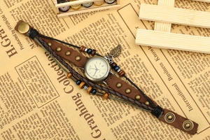 Detail of vintage leather wrap watch with bronze leaf pendant and colorful beads