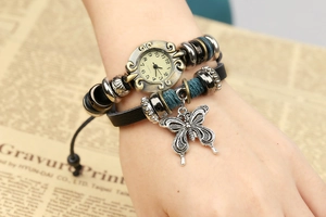 Detail of vintage leather wrap watch with turquoise rope and silver butterfly pendant