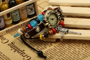 Gros plan sur une montre bracelet en cuir vintage avec cadran en bronze et perles
