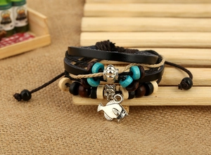 Macro shot of bohemian multi-layer leather bracelet with fish charm and wooden beads