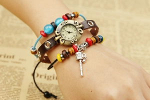 Détail d'une montre bracelet en cuir vintage avec cadran en bronze et perles ethniques