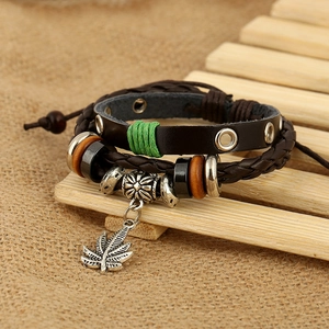 Bracelet multicouche en cuir avec pendentif feuille d'érable sur fond bois rustique