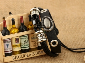 Detail of a black braided leather bracelet featuring vintage silver alloy beads and charms