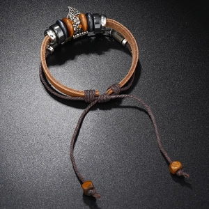 Macro detail of multi-layer leather bracelet with wooden beads and silver metal charms