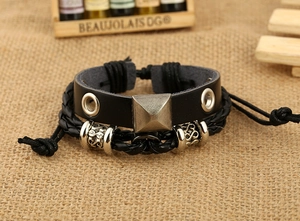 Dettaglio del bracciale in pelle multistrato con borchia a piramide e perline argentate