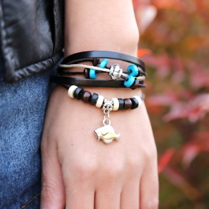 Bohemian multilayer leather bead bracelet featuring a silver fish charm on a model's wrist
