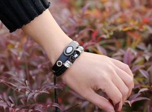 Detail shot of multi-layer black leather punk bracelet with silver metal charms for men