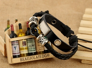 Close-up of multilayer black leather bracelet with silver floral beads and retro metal plates