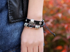 Gros plan sur un bracelet punk en cuir avec clous tête de mort et détails de perles