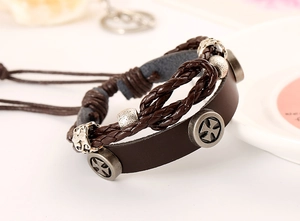 Detail of vintage multilayer leather bracelet featuring cross studs and metallic beads