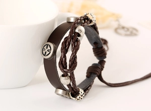 Detail of multi-layer brown leather bracelet with vintage metal rivets and beaded cords