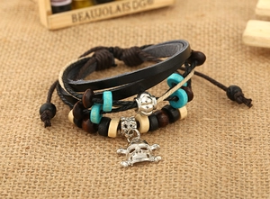Detailed shot of multi-layer leather bracelet with wooden beads and skull charm detail