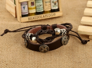 Macro detail of brown leather multi-layer bracelet with silver cross charms and infinity sign