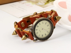 Macro detail of punk quartz watch with brown leather strap and bronze spike studs