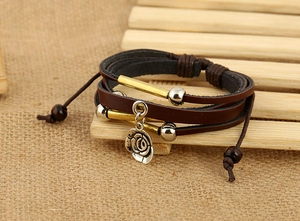 Detail of vintage multilayer leather bracelet with silver rose charm and brass beads