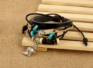 Detail of multilayer leather bracelet featuring wood beads and a silver skull charm