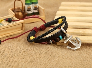 Close-up of handmade multilayer leather bracelet with silver anchor charm and wood beads