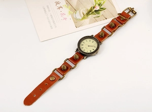 Macro view of vintage punk quartz watch with brown leather strap and bronze spike rivets