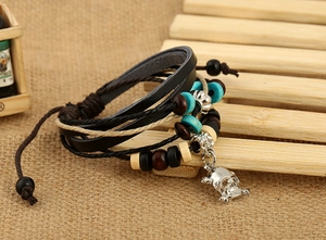 Detail view of multi-layer leather punk bracelet with skull charm and wooden beads