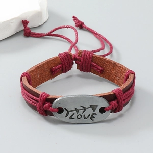 Dettaglio di un bracciale in pelle intrecciata a mano con piastra in metallo LOVE
