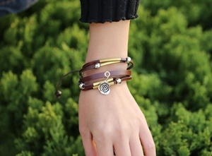 Detail of multi-layer brown leather rose bracelet on wrist with brass beads