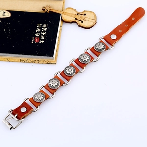 Punk brown leather bracelet with vintage silver star embossed alloy charms on a white surface