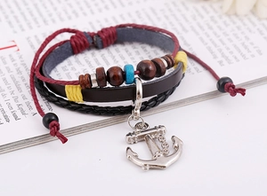 Detail of vintage multilayer leather bracelet with silver anchor charm and beads