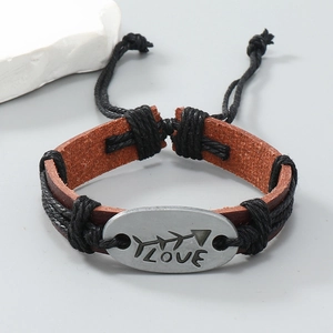 Dettaglio del bracciale in pelle intrecciata con ciondolo LOVE argento e cordino