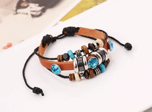 Detail of layered leather bracelet with turquoise stones and wooden beads on white surface