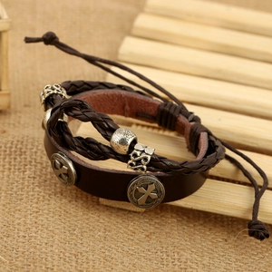 Vintage multilayer genuine leather bracelet with cross charms on textured linen background