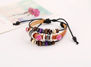 Detail of multi-layer leather bracelet with wooden beads and pink rhinestone buckle