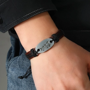 Dettaglio del bracciale in pelle intrecciata a mano con placca in metallo LOVE