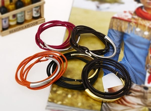 Detail of multi-layer leather wrap bracelets with metal tubes on a fashion magazine
