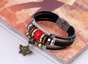 Close-up of vintage multilayer leather bracelet with bronze butterfly charm and beads