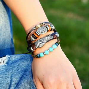 Bracelet multicouche en cuir avec perles et plumes en alliage portés au poignet
