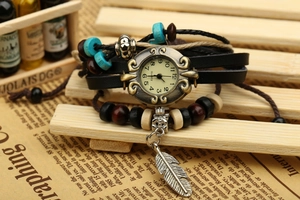 Close-up of bohemian quartz watch featuring multilayer leather straps and feather charm