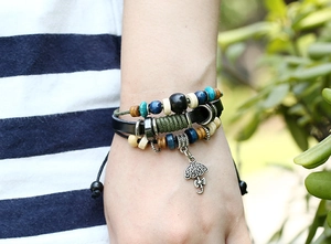 Detail of bohemian multilayer leather bracelet featuring colorful wood beads and umbrella charm