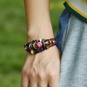 Detail of multi-layer leather bracelet with wooden beads and pink rhinestone accents